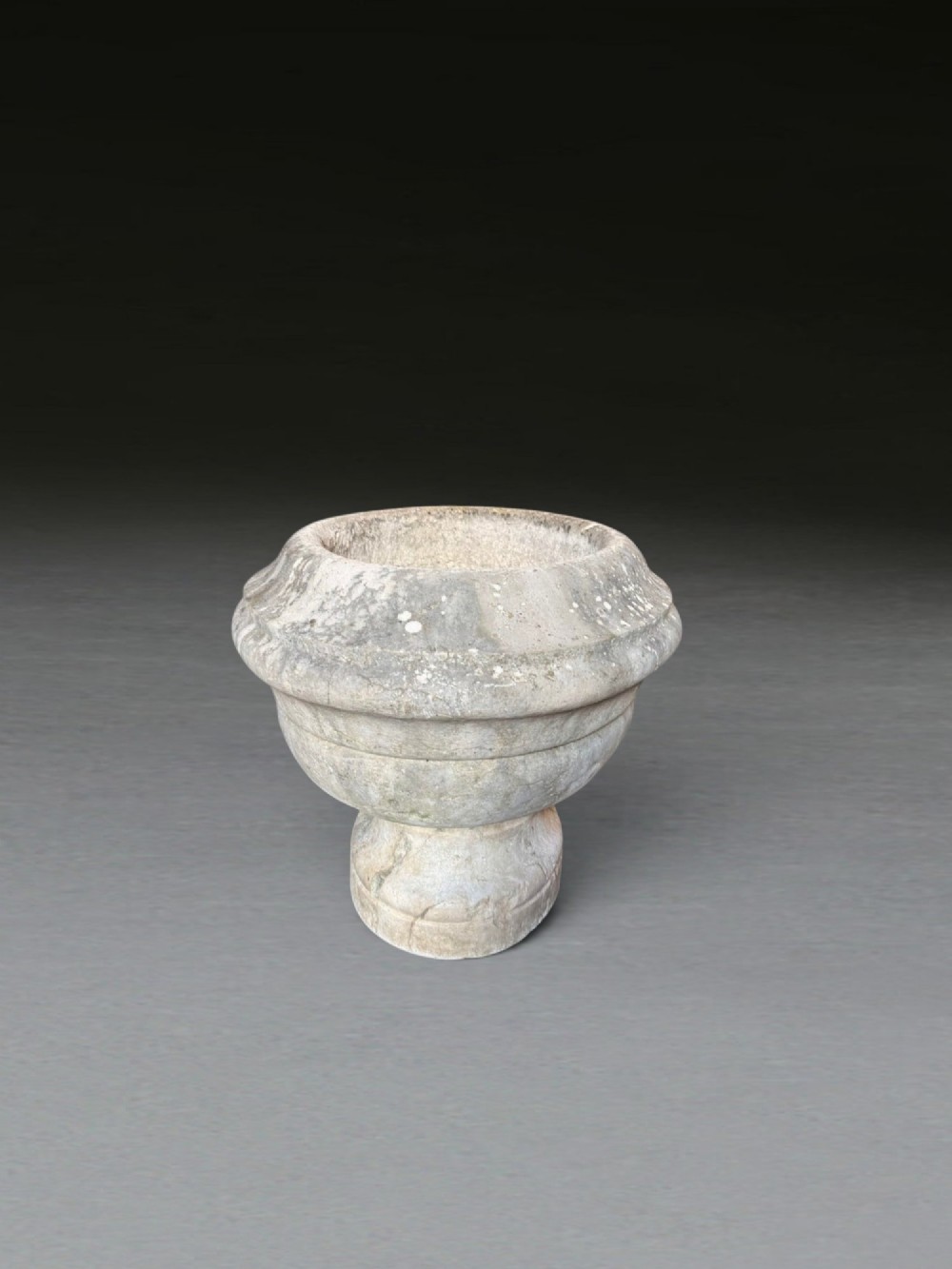 A hand-carved 18th-century grey marble cistern featuring a wide moulded rim and a heavy circular pedestal base. View VIII