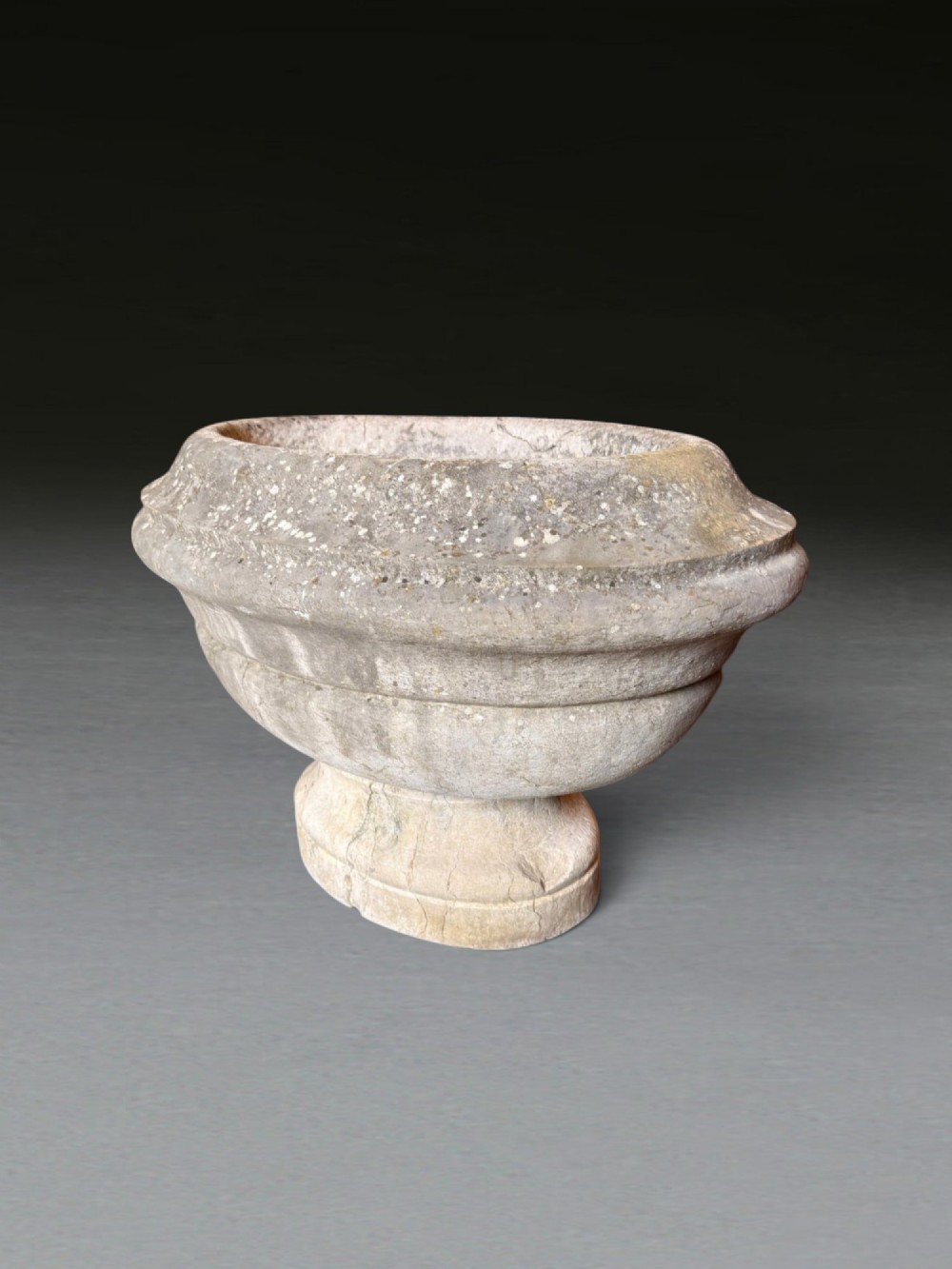 A hand-carved 18th-century grey marble cistern featuring a wide moulded rim and a heavy circular pedestal base. View XIII