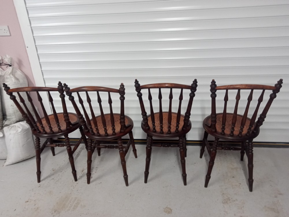 A set of four dark brown Edwardian wooden cafe chairs featuring spindle backs, turned legs, and circular seats with perforated dot patterns. View IX