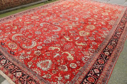 A large antique Persian Heriz carpet featuring an all-over geometric pattern in red, navy blue, and cream tones with a decorative border. View VI
