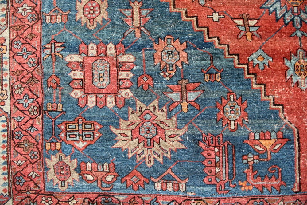 An oversized hand-knotted Persian carpet featuring a central geometric star medallion in light blue and cream on a terracotta field with blue spandrels and patterned borders. View VII