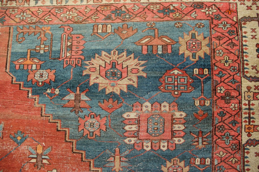 An oversized hand-knotted Persian carpet featuring a central geometric star medallion in light blue and cream on a terracotta field with blue spandrels and patterned borders. View XI
