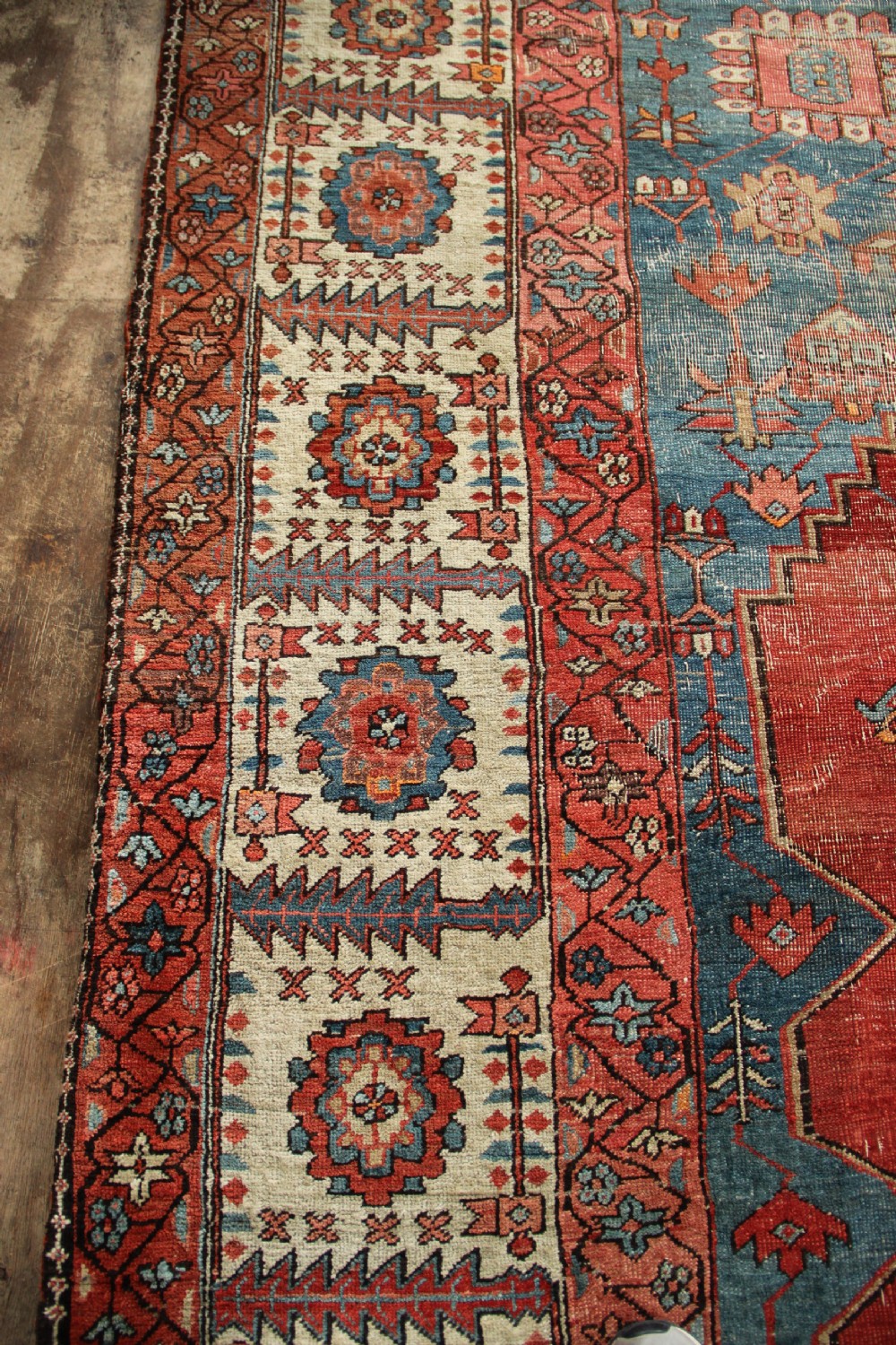 An oversized hand-knotted Persian carpet featuring a central geometric star medallion in light blue and cream on a terracotta field with blue spandrels and patterned borders. View XIV