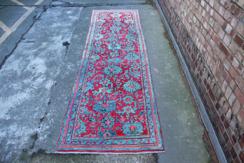 An elongated antique Oushak runner featuring an intricate floral pattern in shades of green and pink on a vibrant ground. View IV