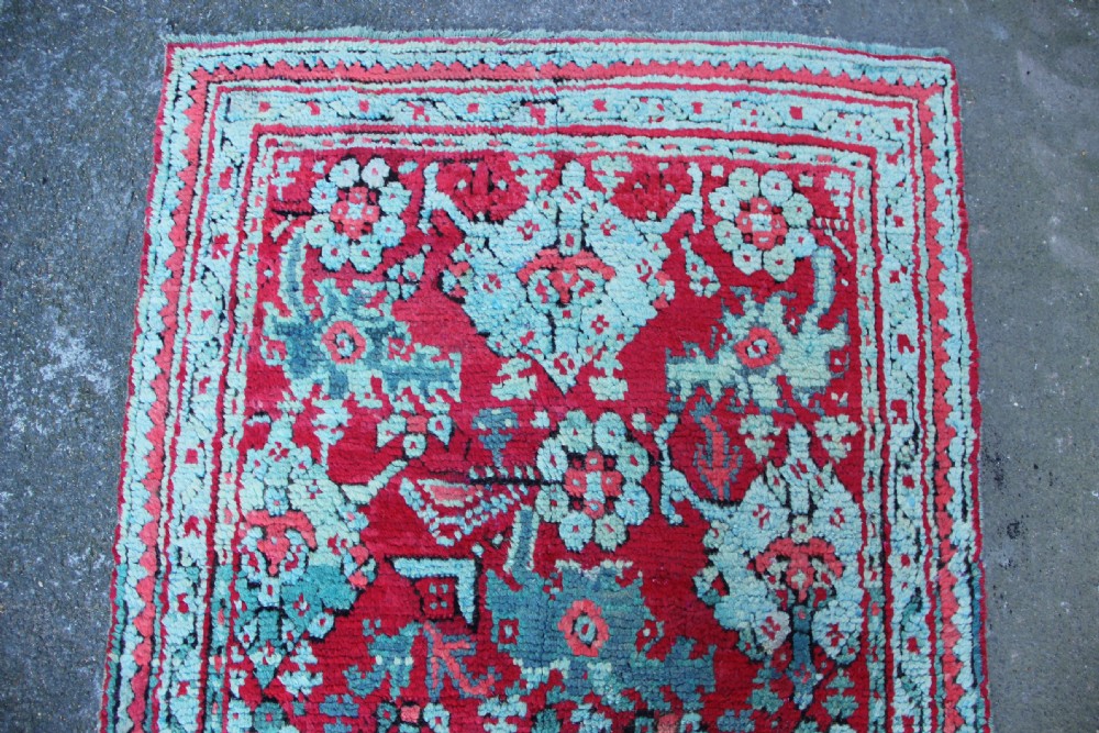 An elongated antique Oushak runner featuring an intricate floral pattern in shades of green and pink on a vibrant ground. View IX