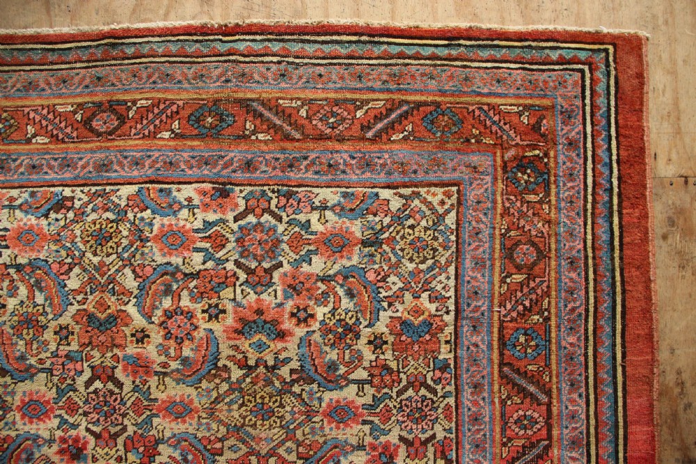 A large hand-knotted antique Bakhshaish wool carpet featuring a dense floral lattice pattern on a cream field surrounded by a terracotta border. View VI