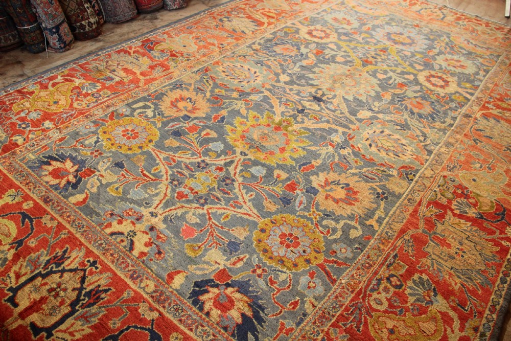 A large hand-knotted antique Ziegler carpet featuring a slate-blue field with all-over botanical palmettes enclosed by a terracotta floral border. View III