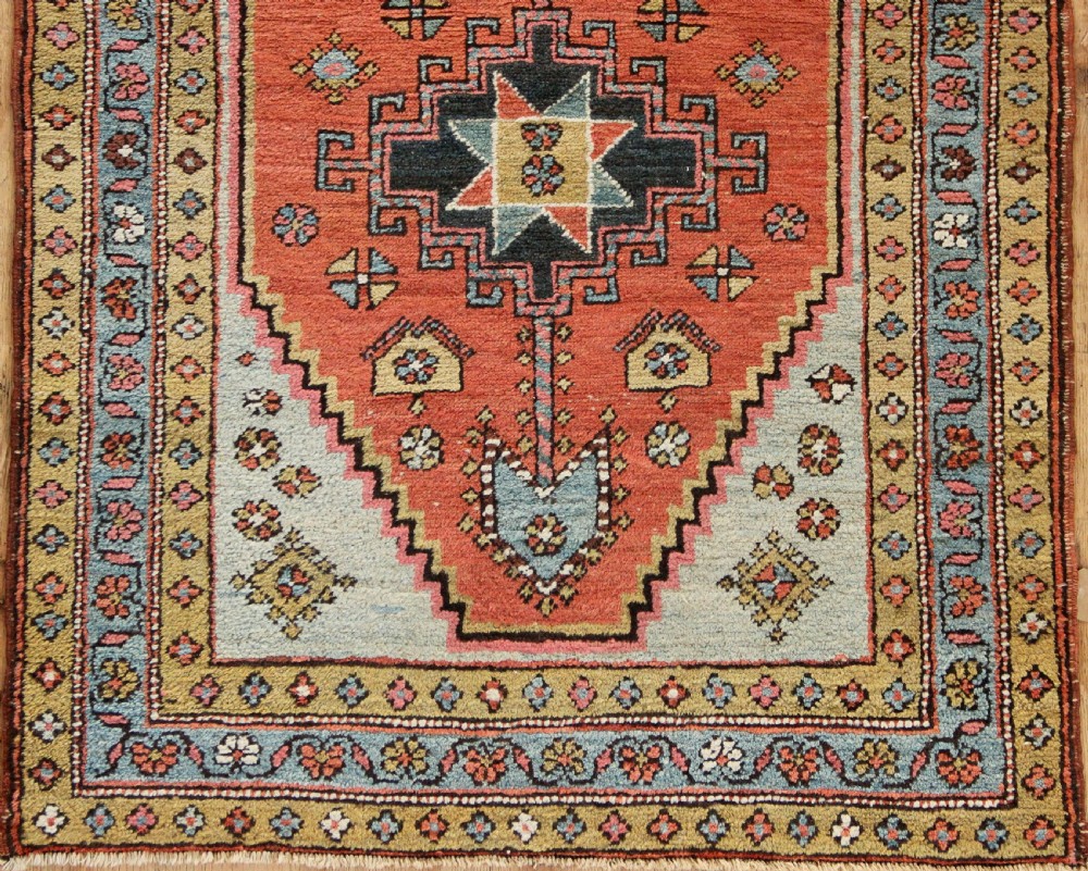 Hand-knotted wool Heriz rug featuring a central terracotta stepped medallion framed by light blue spandrels and patterned borders. View II