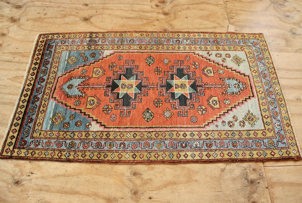 Hand-knotted wool Heriz rug featuring a central terracotta stepped medallion framed by light blue spandrels and patterned borders. View VII