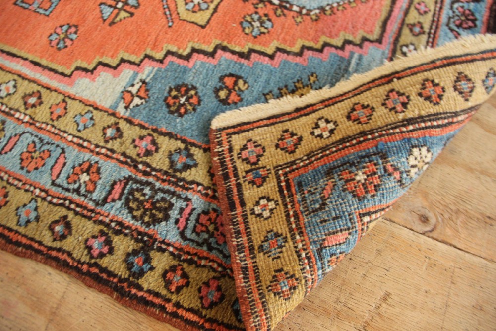 Hand-knotted wool Heriz rug featuring a central terracotta stepped medallion framed by light blue spandrels and patterned borders. View XI