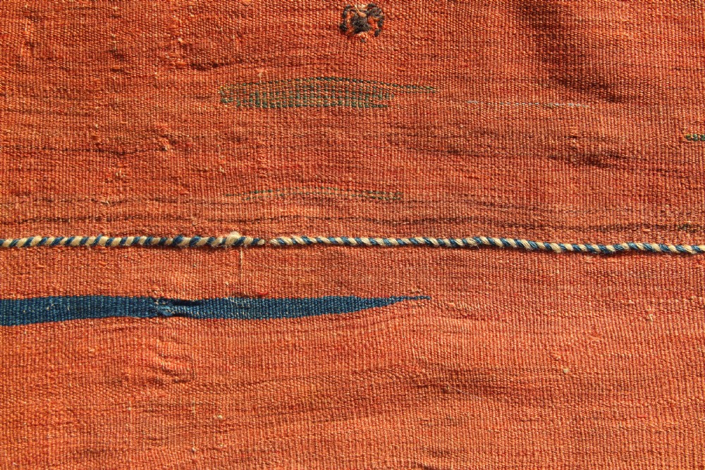 A square antique Kurdish woven saddlebag face displaying geometric borders in blue, red, and yellow surrounding a central medallion with woven bottom loops. View VII