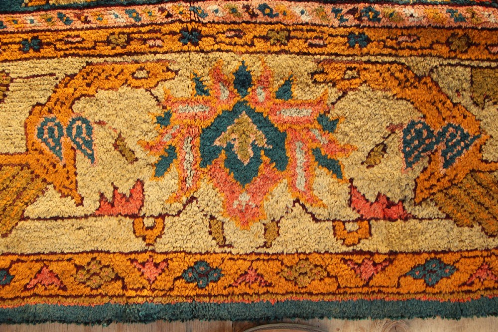 A large hand-knotted antique Oushak wool carpet featuring a central stepped medallion on a teal field surrounded by cream and gold floral borders. View IX