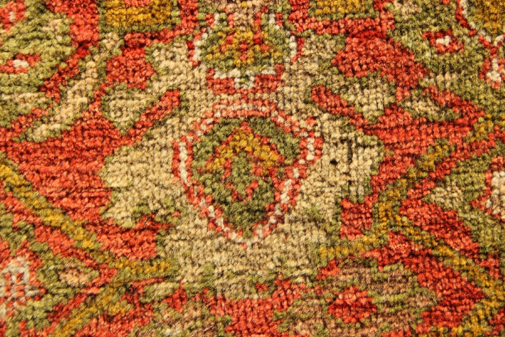A square hand-knotted antique Ziegler wool carpet featuring a terracotta red field filled with intricate floral palmettes and framed by multi-tiered decorative borders. View V