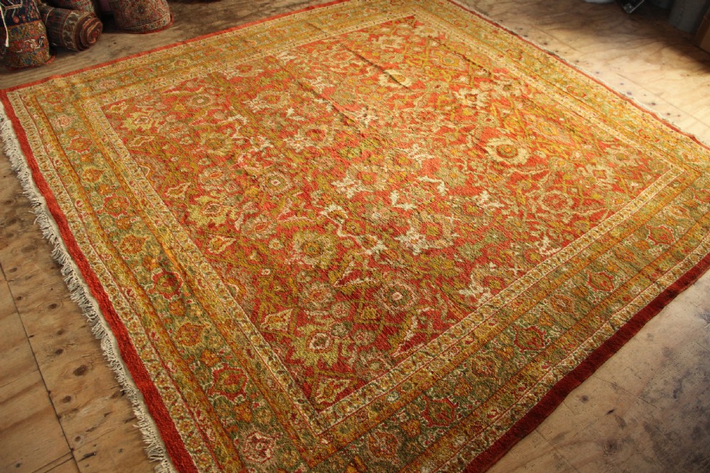 A square hand-knotted antique Ziegler wool carpet featuring a terracotta red field filled with intricate floral palmettes and framed by multi-tiered decorative borders. View VIII