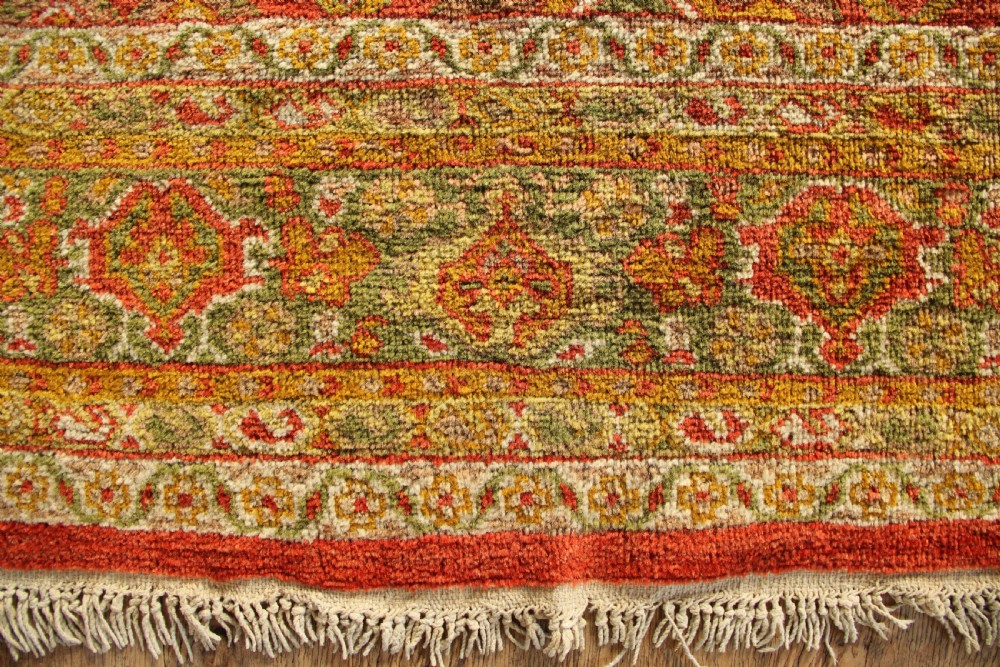 A square hand-knotted antique Ziegler wool carpet featuring a terracotta red field filled with intricate floral palmettes and framed by multi-tiered decorative borders. View IX