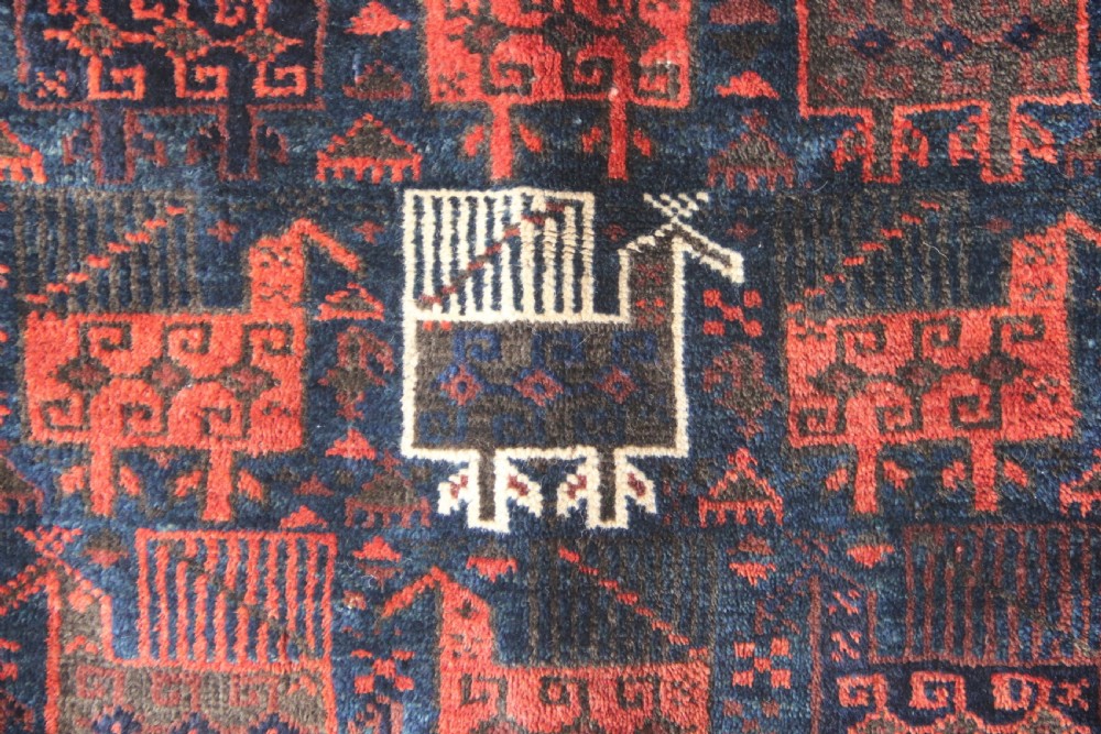 An antique square Belouch woven wool bagface decorated with stylized bird motifs in terracotta red, navy blue, and ivory accents. View II