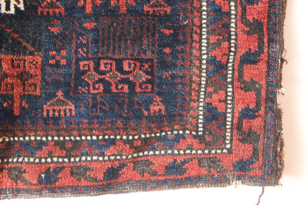 An antique square Belouch woven wool bagface decorated with stylized bird motifs in terracotta red, navy blue, and ivory accents. View III