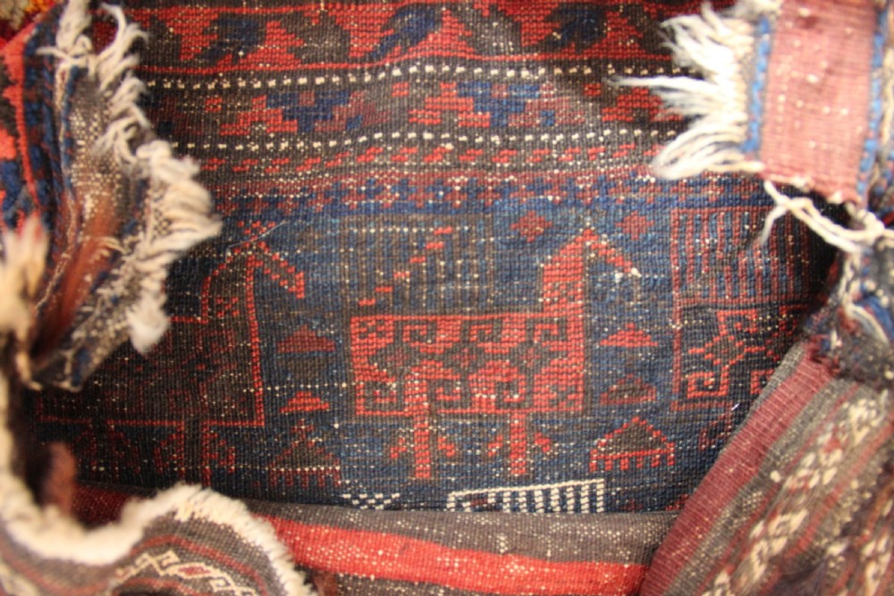 An antique square Belouch woven wool bagface decorated with stylized bird motifs in terracotta red, navy blue, and ivory accents. View V