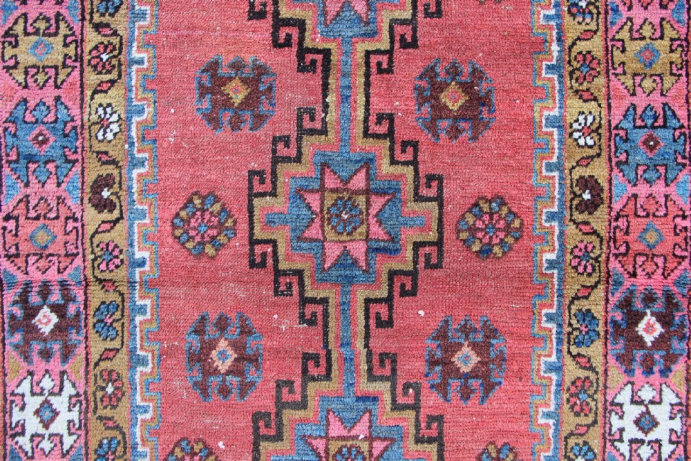 A rectangular hand-knotted antique Bakshaish Persian rug featuring a central terracotta stepped medallion field with blue spandrels and patterned floral borders. View II