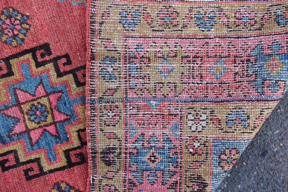 A rectangular hand-knotted antique Bakshaish Persian rug featuring a central terracotta stepped medallion field with blue spandrels and patterned floral borders. View IX