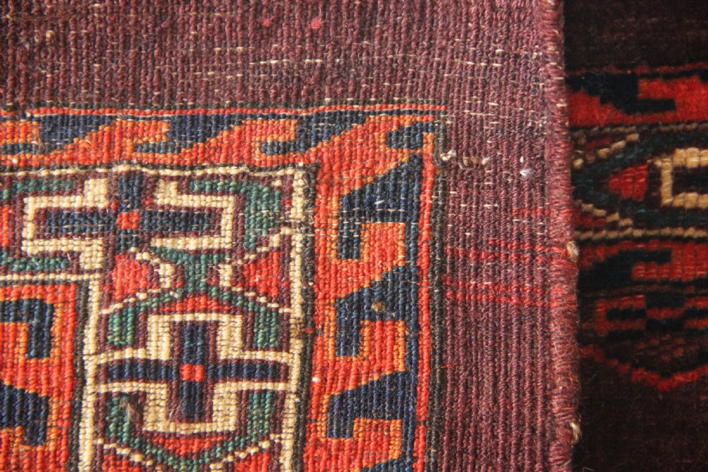 An antique hand-woven Yomud Mafrash wool textile panel featuring repeating geometric gul motifs in dark red, cream, and blue tones. View IX