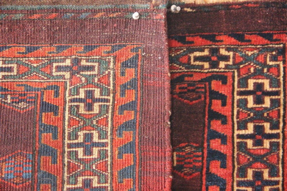 An antique hand-woven Yomud Mafrash wool textile panel featuring repeating geometric gul motifs in dark red, cream, and blue tones. View X