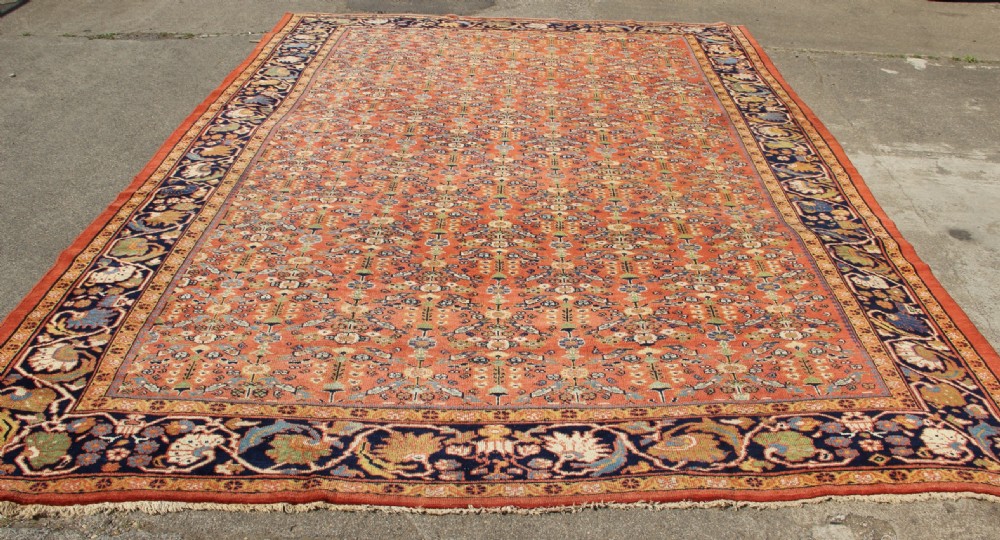 A large antique Persian Mahal carpet featuring an all-over floral lattice pattern in terracotta with a dark navy blue floral border. View XI