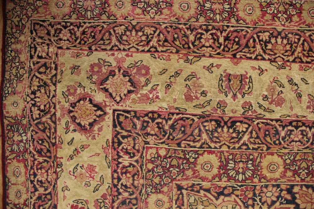 A large hand-knotted Persian Lavar Kirman carpet featuring a complex central floral medallion, intricate corner spandrels, and multi-layered decorative borders in cream, rose pink, and navy blue. View VII