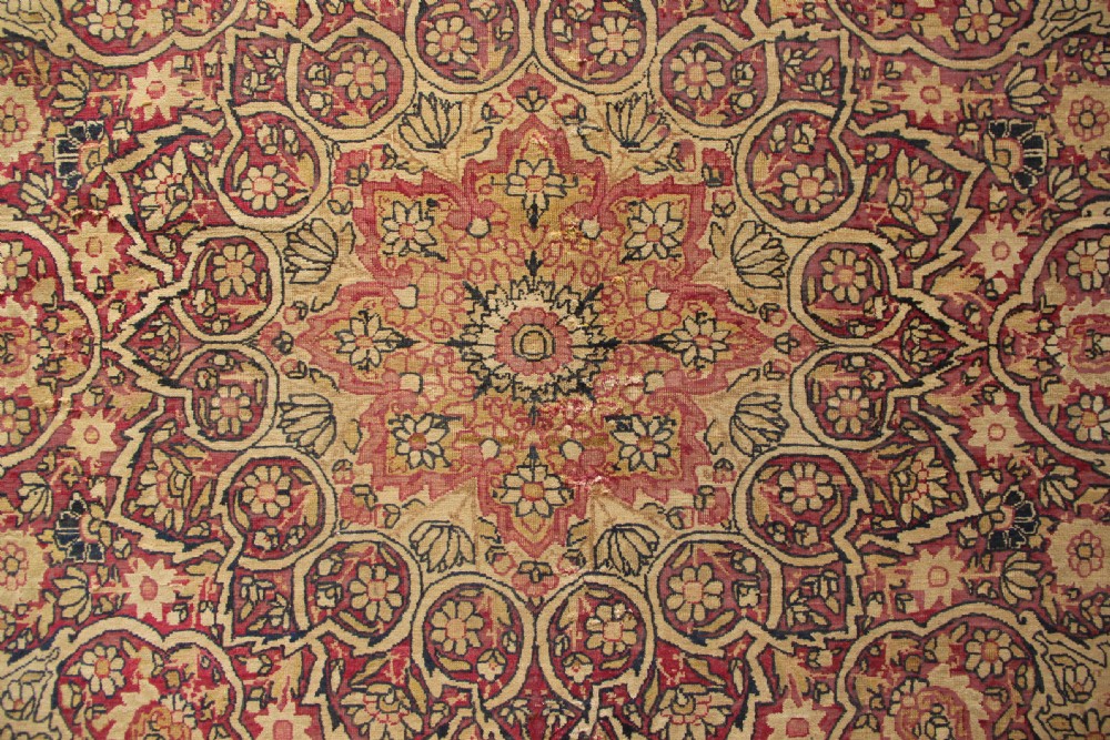 A large hand-knotted Persian Lavar Kirman carpet featuring a complex central floral medallion, intricate corner spandrels, and multi-layered decorative borders in cream, rose pink, and navy blue. View X