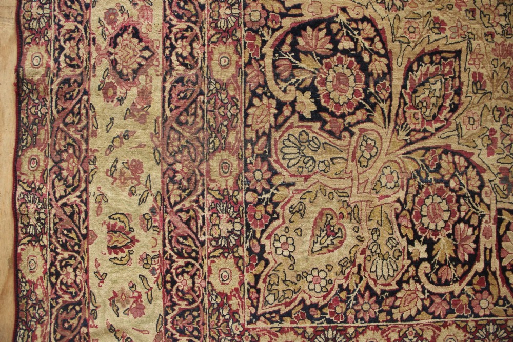 A large hand-knotted Persian Lavar Kirman carpet featuring a complex central floral medallion, intricate corner spandrels, and multi-layered decorative borders in cream, rose pink, and navy blue. View XI