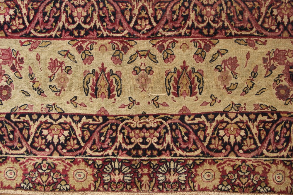 A large hand-knotted Persian Lavar Kirman carpet featuring a complex central floral medallion, intricate corner spandrels, and multi-layered decorative borders in cream, rose pink, and navy blue. View XII