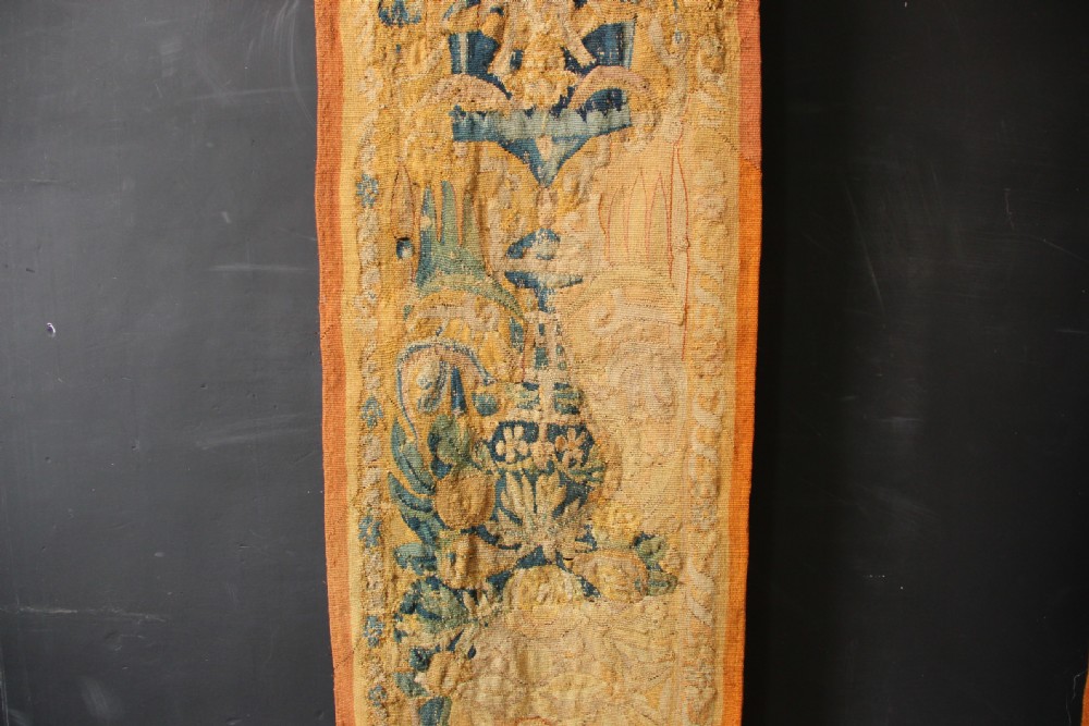 A pair of long vertical 17th-century woven tapestry borders featuring botanical foliage, urns, and floral motifs in yellow, green, and blue tones. View II