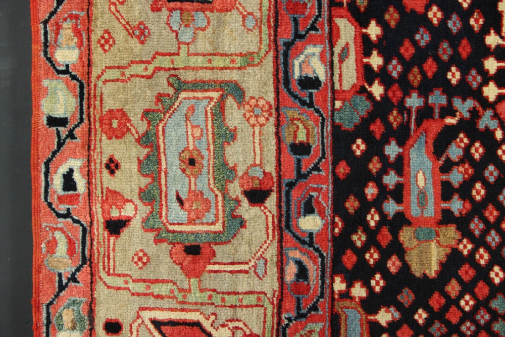 An antique Persian Serapi gallery carpet with a navy blue field featuring repeating boteh motifs framed by a wide sage green ornamental border. View V