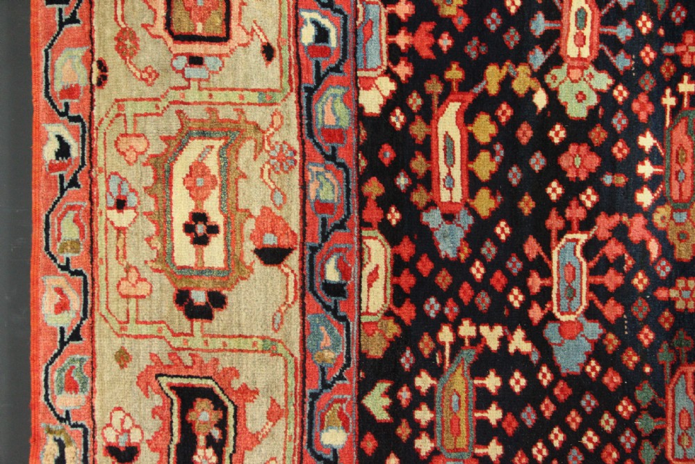 An antique Persian Serapi gallery carpet with a navy blue field featuring repeating boteh motifs framed by a wide sage green ornamental border. View VI
