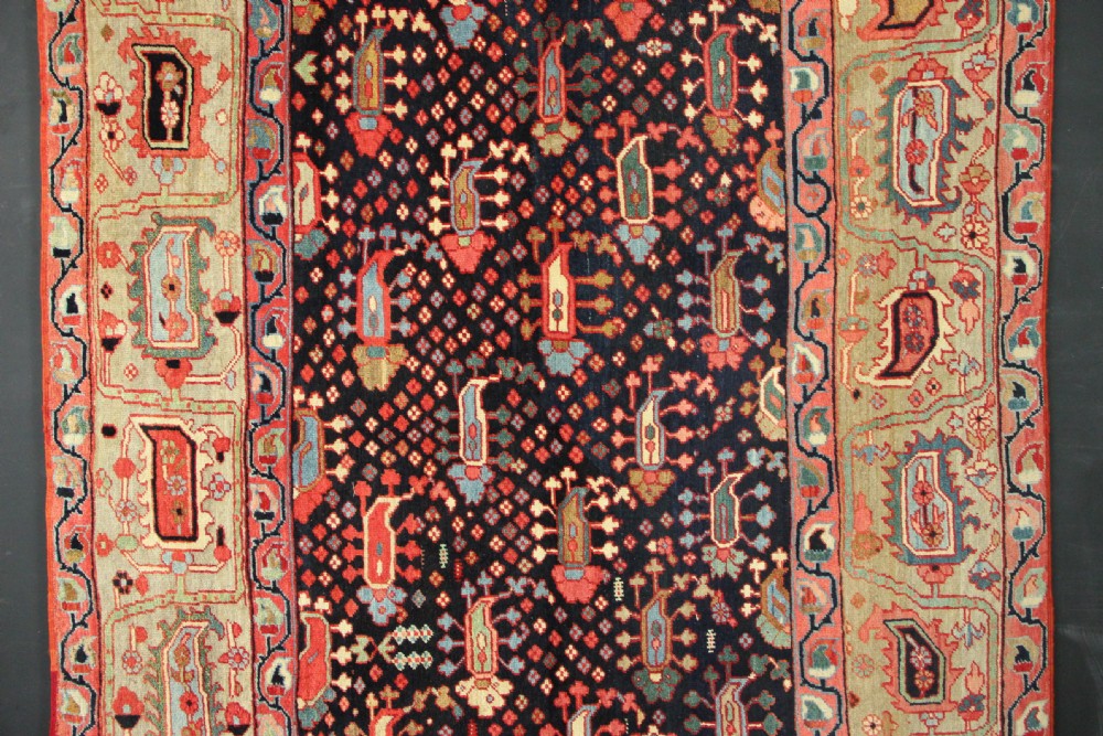 An antique Persian Serapi gallery carpet with a navy blue field featuring repeating boteh motifs framed by a wide sage green ornamental border. View VII