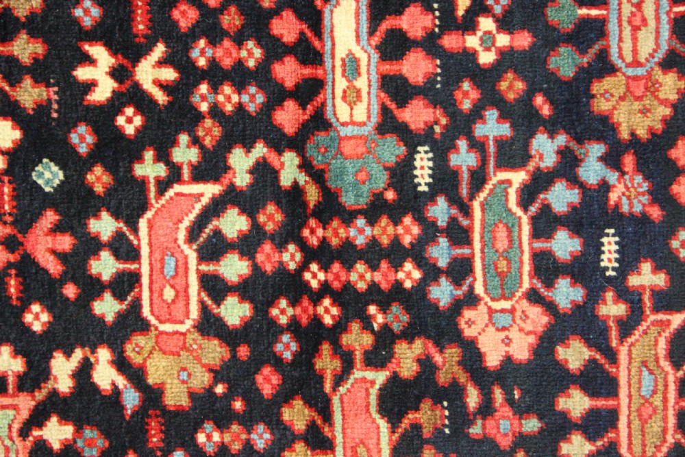 An antique Persian Serapi gallery carpet with a navy blue field featuring repeating boteh motifs framed by a wide sage green ornamental border. View VIII