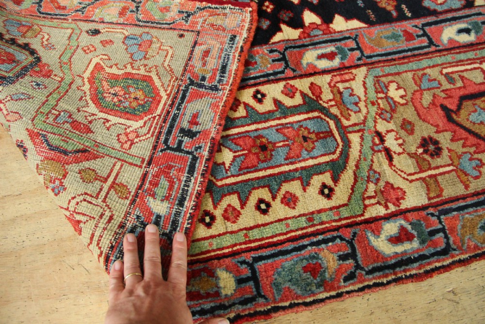 An antique Persian Serapi gallery carpet with a navy blue field featuring repeating boteh motifs framed by a wide sage green ornamental border. View X