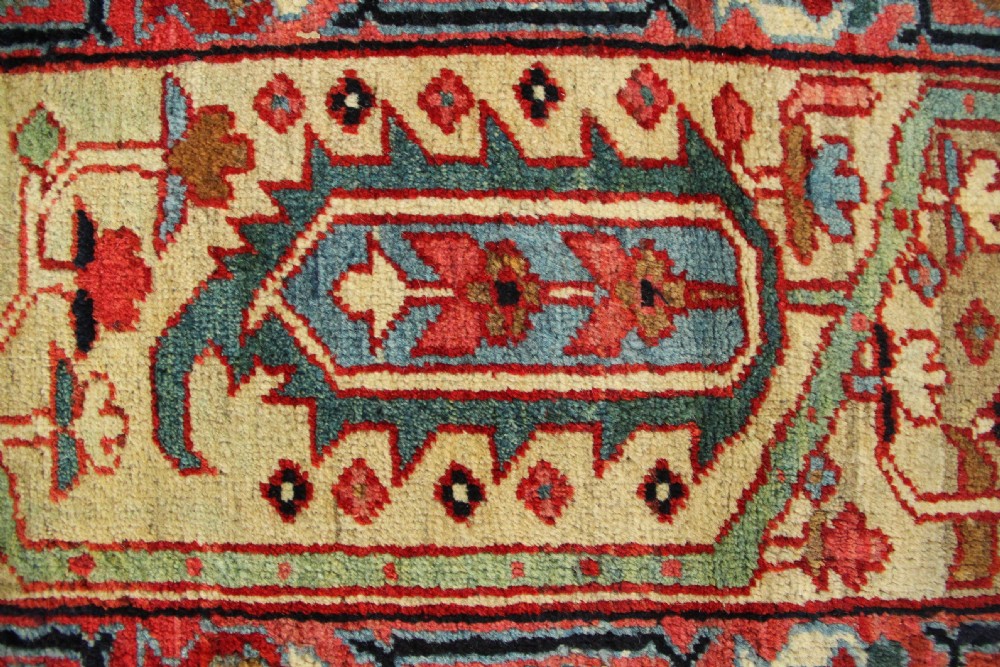 An antique Persian Serapi gallery carpet with a navy blue field featuring repeating boteh motifs framed by a wide sage green ornamental border. View XI