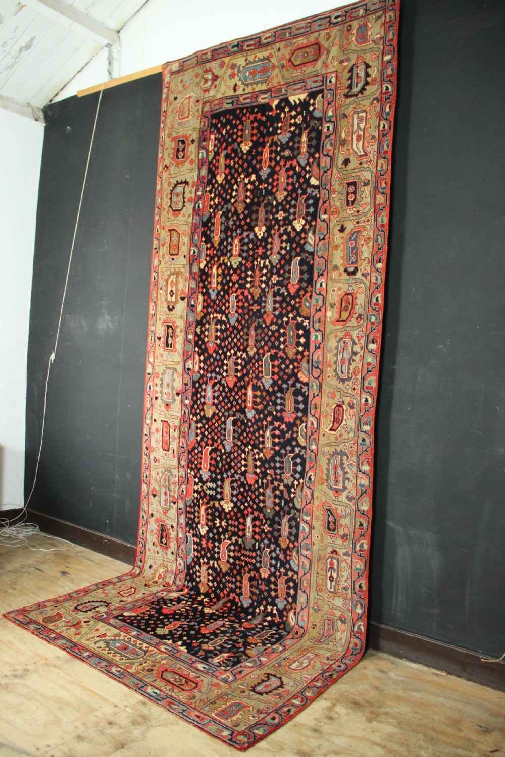 An antique Persian Serapi gallery carpet with a navy blue field featuring repeating boteh motifs framed by a wide sage green ornamental border. View XIII
