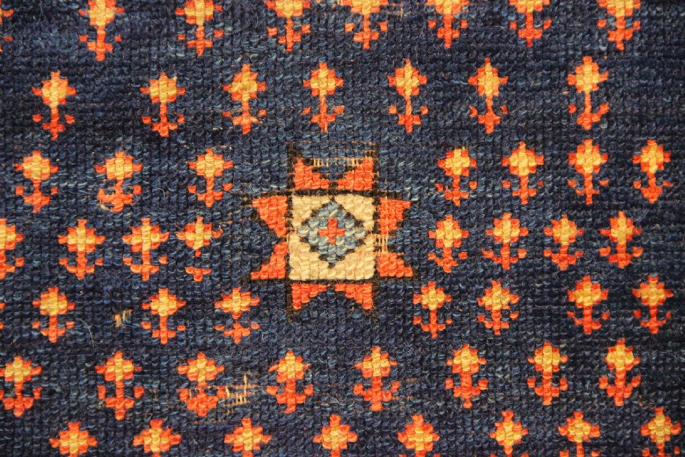An early nineteenth-century Anatolian Konya yastik rug featuring a central navy blue diamond medallion set against a terracotta woven background with geometric borders. View II