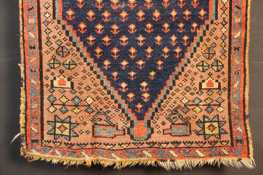 An early nineteenth-century Anatolian Konya yastik rug featuring a central navy blue diamond medallion set against a terracotta woven background with geometric borders. View V