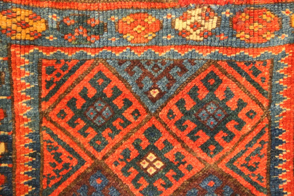 An antique handwoven Jaf Kurd wool saddlebag face featuring diamond latch-hook medallions in red, blue, and yellow. View II