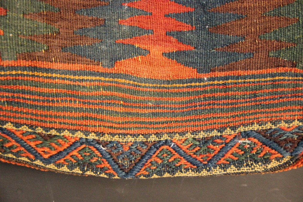 An antique handwoven Jaf Kurd wool saddlebag face featuring diamond latch-hook medallions in red, blue, and yellow. View VI