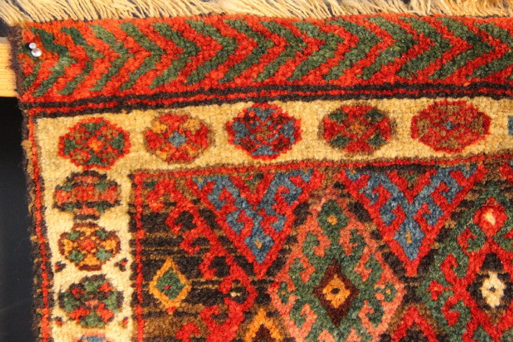 A square antique hand-knotted Jaf Kurd wool saddlebag face with geometric diamond lattice patterns in red, blue, green, and cream tones. View IV