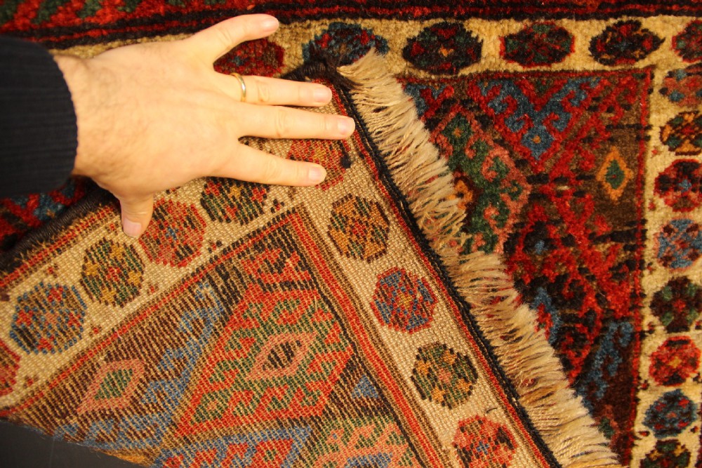 A square antique hand-knotted Jaf Kurd wool saddlebag face with geometric diamond lattice patterns in red, blue, green, and cream tones. View V