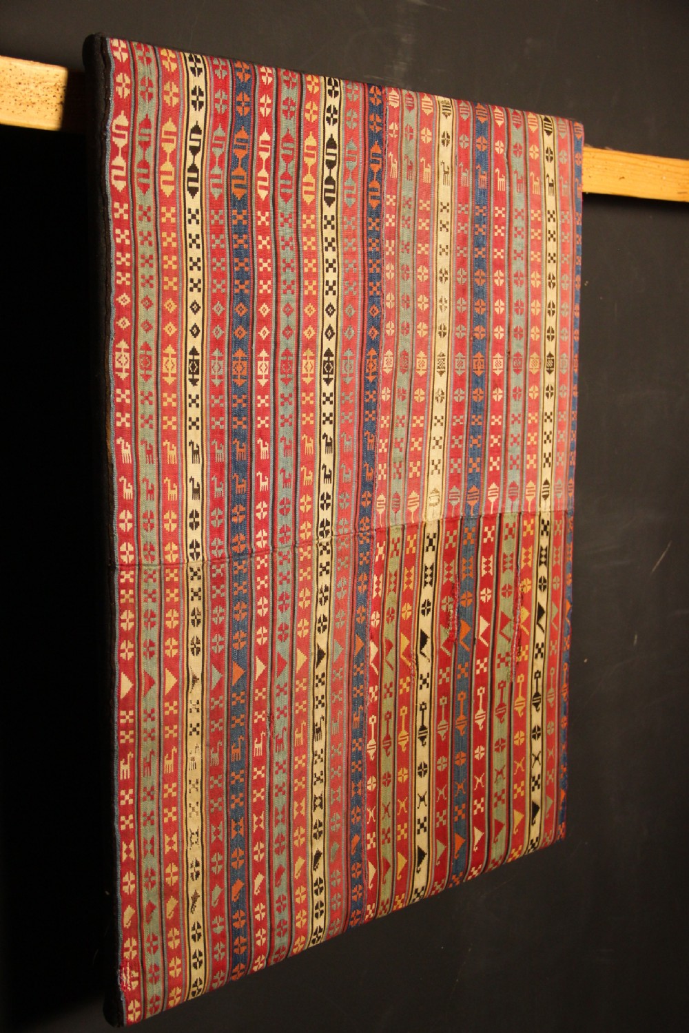 A rectangular mounted 19th-century silk jajim textile featuring vertical stripes with intricate geometric and stylized animal motifs in red, blue, cream, and yellow hues. View VIII