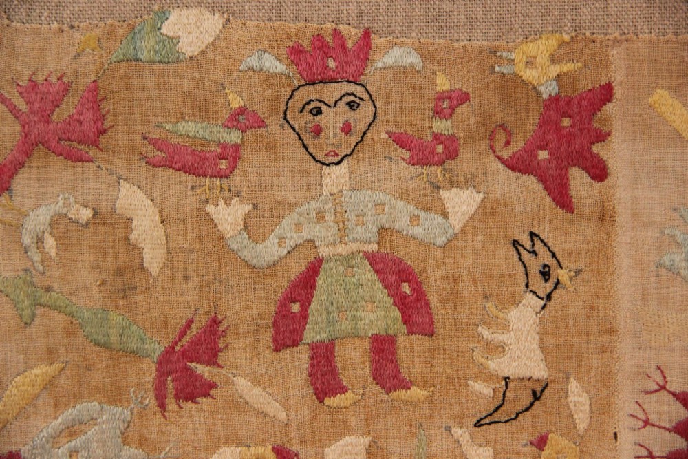 An antique hand-embroidered linen textile fragment from Skyros featuring red and green silk threads depicting human figures, birds, and floral motifs. View VI
