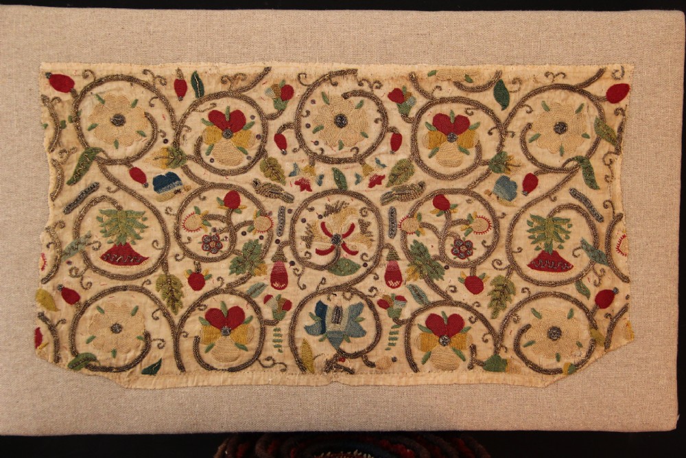 An unstitched early 17th-century rectangular linen embroidery panel decorated with scrolling metallic tendrils and polychrome silk flowers.