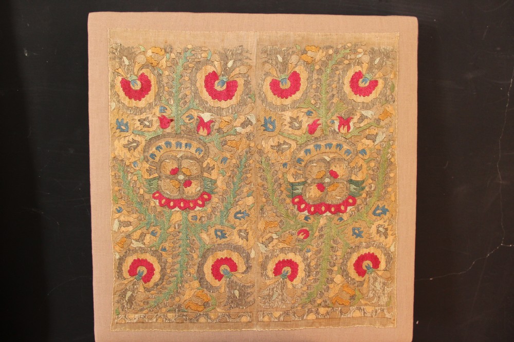 An 18th-century Greek embroidered linen panel featuring symmetrical botanical motifs stitched in red, green, ochre, and metallic thread.