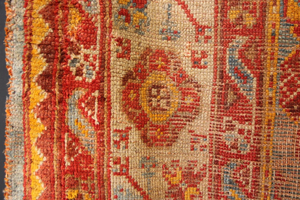 A large antique Turkish Oushak wool carpet featuring a pale blue field layered with terracotta and gold medallion motifs and a patterned border. View XII